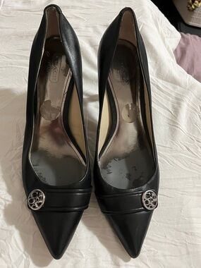 Coach Black Pointed Toe Heels with Silver Logo Medallion